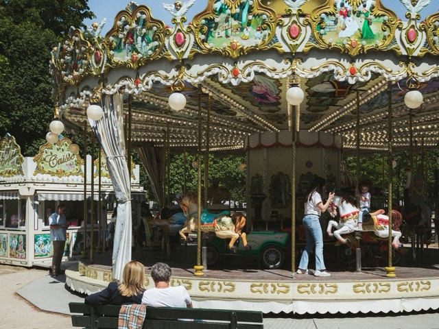 An ornate carousel turning beneath decorative lights