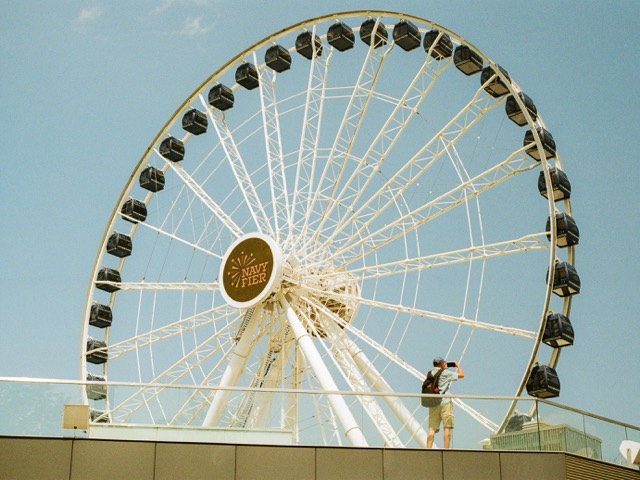 A white Ferris wheel against a pale blue sky