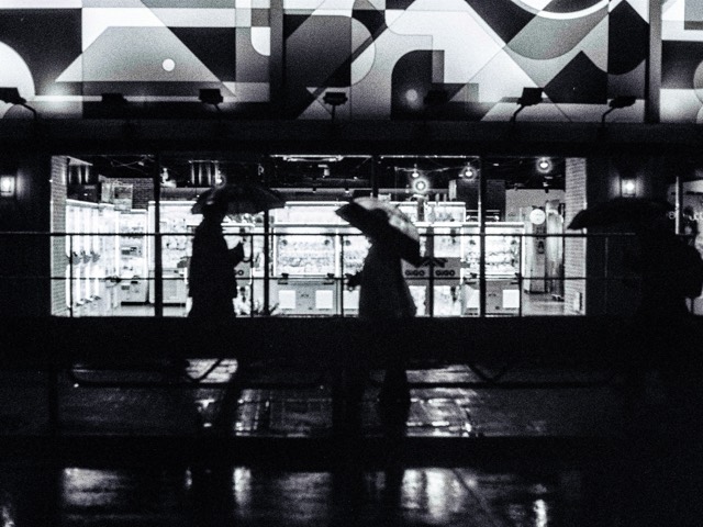 A silhouetted visitor inside a geometric black-and-white interior